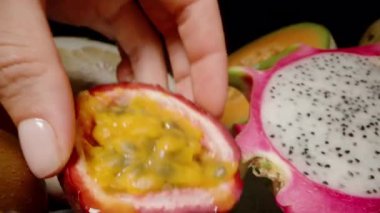 El Tutuşunun Dolly Kaydırıcısı Yarı Tutku Meyvesi Sulu Sarı Pulp ve Siyah Yüzeyde Ejderha Meyvesi Tohumlarını Gösteriyor