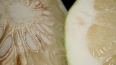 Siyah Arkaplana Karşı Simetrik Düzenlemede Soluk Şeffaf Bölümleri ve Beyaz Kabuğu Gösteren İki Pomelo Yarısının Dolly Kaydırma Kapanışı