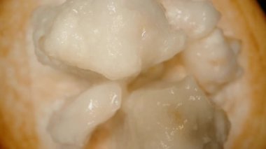 Santol Yarı Dönüyor ve Yavaş Yavaş Aşağı Çekiliyor, Sulu Beyaz Pulp Odakta, Makro 'da Üst Görünüm, Düşen Hareket Etkisi, Egzotik Meyve Konsepti