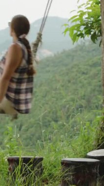 Dikey video. İp üzerinde sallanan Kadın Görünümü Görüntü Görüntü Görüntü Görüntü Görüntü Görüntü Görüntü Görüntü Dağlarına Karşı Görüntü Görüntü Görünümü Orta Hareket, Açık Hava Özgürlük Konsepti