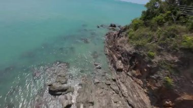 İnsansız hava aracı Rocky Shoreline 'a ve Turkuaz Denizi' ne doğru hızla iniyor Hareket Bulanıklığı ve Yeşil Görünümlü Macera Aksiliği