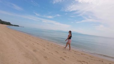 Sakin Mavi Deniz ve Açık Gök, Seyahat ve Yalnızlık Altındaki Uzak Adalar 'la birlikte İHA daireler çizerken Altın Sahilde Yürüyen Kadın