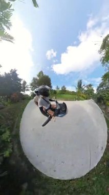 Dikey video. Beton Yolu 'nda, Scooter Yolu' ndaki çift. Etrafı, Minik Gezegen Efekti 'nde Yakalanmış Ağaçlarla çevrili. Senaryo Yolculuğu Macerası Konsepti.