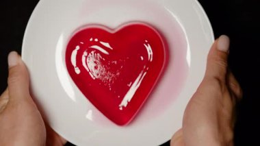 Kırmızı Kalp Şekilli Jöle Nazikçe Beyaz Tabakta Sallanırken Eller Yanları Tutar, Baş Açısı Yavaş Hareket Etkisi, Romantik Tatlı Konsepti