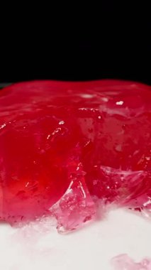 Dikey video. Kırmızı Jöle 'nin Parçası Plate in Mid Air' de Sıçrama Hareketi, Yan Kapanış Görünümü Yavaş Hareket, Etki ve Doku Konsepti