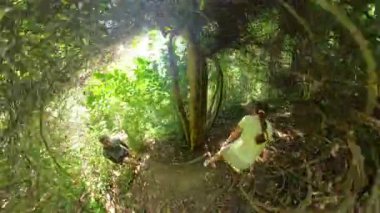 Çevrelenmiş eğri sarmaşıklarla çevrili Orman Yolu 'nda Dinlenen Erkek ve Kadın Tropikal Keşif Sırasındaki Duraksamayı Temsil Ederek Küresel Panorama' da Yakalandı