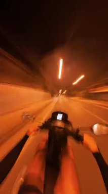 Dikey video. Gece Scooter süren kişi İlk Kişi Açısı 'ndan Görüntü Bulanık Hareket Etkisi ve Işık İzleri ile Karanlık Yol' da Hızlandırılmış Bakışla Yakalandı