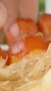 Dikey video. Olgun Pandanus Meyve Kümesinin İçinden Çeken Parmaklar Fibröz Sarı Merkezi ve Yakın Çekim Kırmızı Bölüm, Dolly Kaydırma Hareketi, Egzotik Beslenme Konsepti