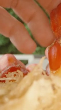 Dikey video. Lezzetli Kırmızı Pandanus Bölümü El Tarafından Parçaların Arasında Gerinen İplikçikler, Dolly Kaypak ve Düşük Açı, Tropikal Hasat Konsepti ile Ayrılıyor