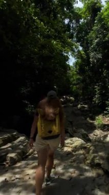 Dikey video. Drone Sırt çantalı Kadını Ormanda Yürüyüşü Takip Ediyor Sonra Yoğun Ağaç Tepesi 'nden Yukarı Yükseliyor, Arka İzleme ve Yükselme Çekimi, Tayland Samui Adası Keşif Konsepti