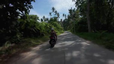 Scooter 'da Kadın Kovalamak Yoğun Tropikal Ormanda Arka planda Dağlar, Düşük Takip Açısı, Tayland Samui Adası Seyahat Konsepti