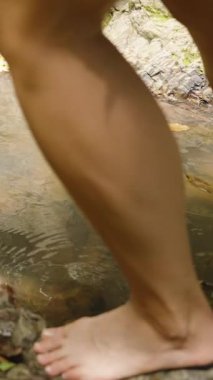 Dikey video. Kadın Suyla, Doğa Enerjisi ve Neşe Konseptiyle Oynarken, Ayak Orman Havuzunda Dinamik Sıçrama Oluşturur