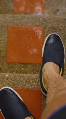 Dikey video. Yağmur Altındaki Merdivenlerdeki Islak Bacaklar ve Siyah Ayakkabılar Yavaş Hareket Eden Su Damlacıkları, Tropikal Sağanak Konsepti