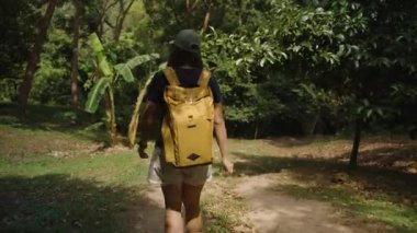 Sarı Sırt Sırtçantalı Kadın Tayland 'da Güneş Yolunda Yürüyüşü Tropikal Bitkiler ve Muz Ağaçları, Ön Arka Görüş, Orta Atış, Ekvator Kavramı