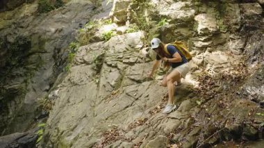 Ormanda Kaygan Yosun Giden Kadın, Güneş Işığı Altındaki Denge Kayışları İçin Sırt Çantası Tutma Yolunda, Doğada Dikkatli Seyrüsefer kavramı