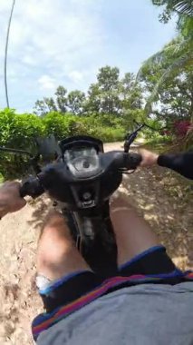 Dikey video. Motosikletli Adam Tropikal Orman Yolunda İlk Kişi Açısı 'ndan Görünür Aynalar ve Hız göstergesi, Macera Yolculuğu ve Arazi Yolculuğu Konsepti ile Yakalandı