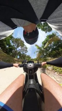 Dikey video. Küresel Panorama, Scooter 'la Ormanda Eğri Sürüşü, Genişletilmiş Kolları, Küçük Gezegen Etkisi, Seyahat Özgürlüğü ve Teknolojisi kavramını gösteren adam.