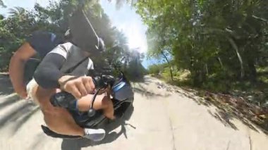 Rider 's Hands Holding Scooter Handlebar' ı, Miğfer ve Koşum Görünür, Tayland 'da Macera Yolculuğu Konsepti Samui ile Palm Tree Yolu boyunca yürürken kapat