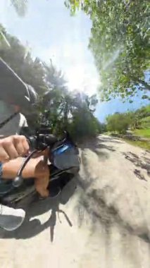 Dikey video. Rider 's Hands Holding Scooter Handlebar' ı, Miğfer ve Koşum Görünür, Tayland 'da Macera Yolculuğu Konsepti Samui ile Palm Tree Yolu boyunca yürürken kapat