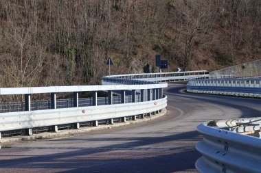 Virajları kıvrımlı dağ yolu, güvenlik sistemleri ve parmaklıkları var.