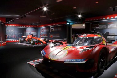 Maranello, Modena, İtalya, 23 Haziran 2024 - Maranello Ferrari Müzesi, ön planda Ferrari 499 P Le Mans ve arka planda Charles Leclerc 'in Ferrari SF 24