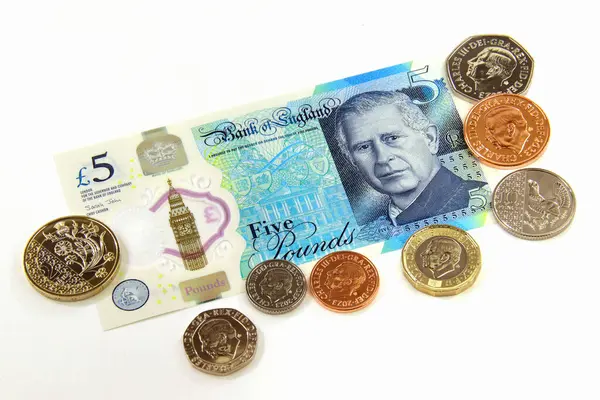 stock image United Kingdom, June 5 2024 - Issue of new pound notes with the image of King Charles III and circulating series of new coins, still life on the white background