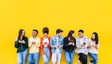 Çok ırklı genç arkadaşlar cep telefonlarında medya içeriğini paylaşırken eğleniyorlar - Milenyum çeşitliliği olan insanlar birlikte akıllı telefon kullanıyorlar - sosyal medya eğilimleri ve teknoloji kavramı