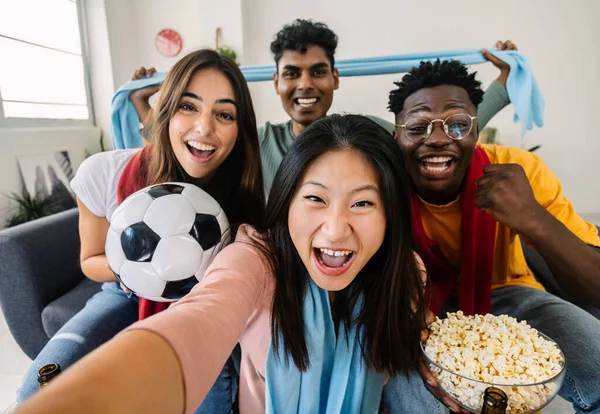 stock image Excited multiracial young friends taking selfie portrait together with phone while watching football match on television at home - Home party and soccer championship concept