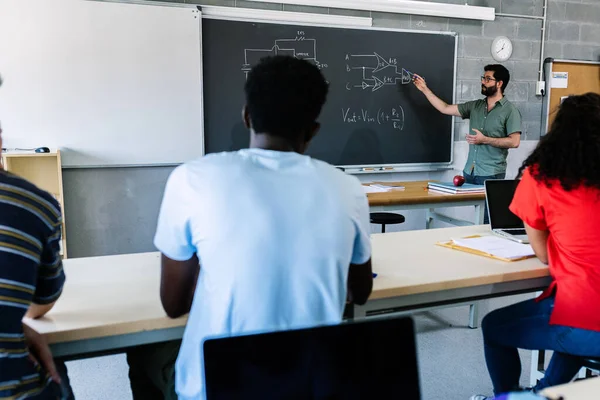 Νεαρός Δάσκαλος Λυκείου Μπροστά Από Μαυροπίνακα Που Διδάσκει Ηλεκτρονικό Μάθημα — Φωτογραφία Αρχείου