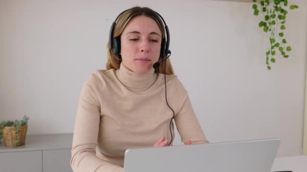 在客户服务部门使用笔记本电脑应用程序与客户交谈的年轻成年女性 在呼叫中心与电话耳机打交道的女操作员微笑 — 图库视频影像