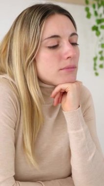 Genç yetişkin bir iş kadınının dizüstü bilgisayarında oturmuş ilham verici fikirleri düşünürken çekilmiş dikey görüntüleri.