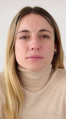 İş yerinde oturan genç ve güzel girişimci iş kadınının portresinin kamera görüntüsü. Kendine güvenen küçük işletme sahibi kadın ofis kamerasına gülümsüyor..