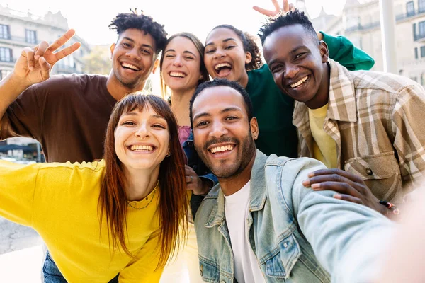Mutlu, genç, çok ırklı en iyi arkadaşlar açık havada eğleniyor. Milenyum çeşitliliği olan insanlar şehrin sokaklarında selfie çektirip eğleniyorlar.