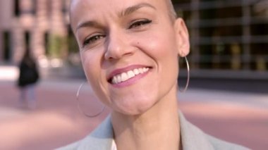 Kısa saçlı, kendine güvenen orta yaşlı bir iş kadını kameraya bakıyor. Finans bölgesinde başarılı bir bayan yönetici duruyor. Yüksek kalite 4k görüntü