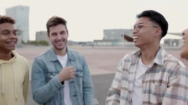 Gülümseyen bir grup çok ırklı genç arkadaş dışarıda birlikte gülüyorlar. Çok ırklı insanlar birlikte eğleniyor ve hafta sonları eğleniyorlar. Arkadaşlık ve mutluluk kavramı