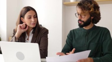 Genç iş adamları yeni proje üzerinde tartışıyorlar. Gündelik giysiler içindeki modaya uygun genç adam iş yerinde birlikte oturan bayan meslektaşla konuşuyor. Takım çalışması ve kurumsal iş dünyası konsepti