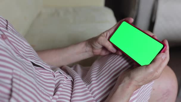 Starší Žena Drží Mobilní Telefon Zelenou Horizontální Poloze Sedí Pohovce — Stock video
