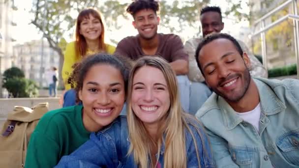 幸せな若い人たちの肖像グループのカメラの屋外で笑顔 街の通りで一緒に座ってリラックスして千年多様な友人 友情と若者のライフスタイルのコンセプト — ストック動画