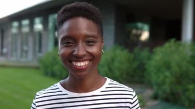 Dışarıdaki kameraya gülümseyen mutlu siyah kadın portresi.. 