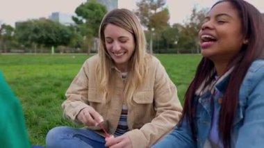 Şehir parkında sabun köpüğü üfleyerek eğlenen çok ırklı genç kadınlar. Kadın arkadaşlığı ve mutluluk kavramı