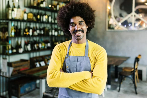 Small businessSmall business african american owner with arms crossed smiling at camera standing at restaurant bar. Small business entrepreneur people concept