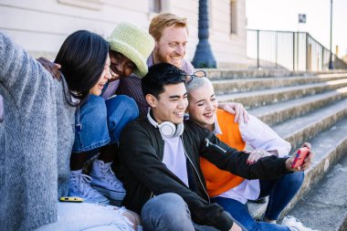 University student friends having fun sharing media content on social media app. Technology and people lifestyle