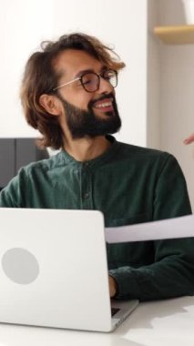 Vertical video of unrecognizable elegant young businesswoman showing graphic results to his male colleague at coworking workplace. Teamwork and business people concept