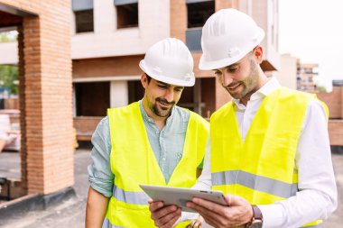 Two successful engineer architect males discussing about building construction project