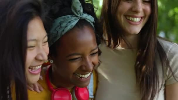 3つの統一された多民族の女性の友人一緒に屋外で笑って楽しんでいる 休日を楽しみながら笑う100万人の女性の若い大人のグループ — ストック動画