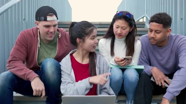 キャンパス大学の階段に座っている若い多人種の大学生は ラップトップコンピュータを使用してグループワークプレゼンテーションを準備します Erasmus Peopleとチームワークのコンセプト — ストック動画