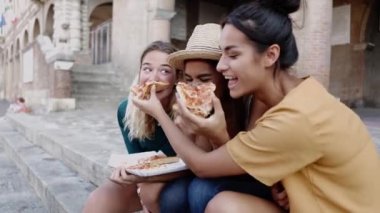 İtalya 'da yaz tatillerinde sokakta pizza yiyen üç tane çok ırklı kadın arkadaş. Gençlerin yaşam tarzı ve kadın arkadaşlığı kavramı