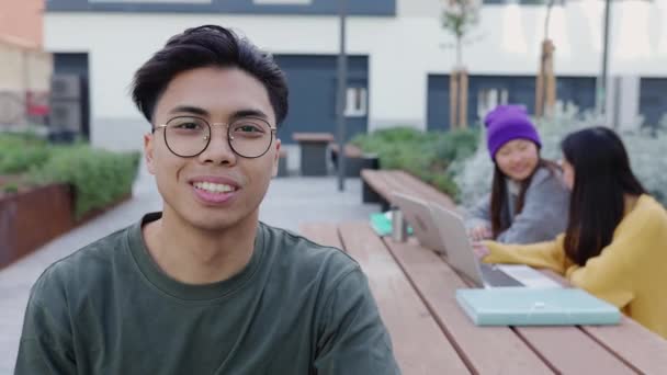Πορτρέτο Του Νεαρού Ασιάτη Που Χαμογελάει Στην Κάμερα Καθισμένος Στο — Αρχείο Βίντεο