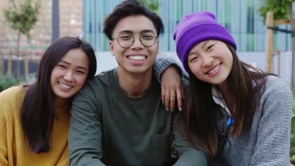 Νέοι Ενήλικες Ασιάτες Έφηβοι Αγκαλιάζονται Ενώ Κάθονται Μαζί Έξω Ομάδα — Αρχείο Βίντεο