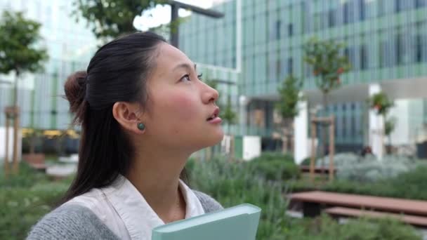 Ofis Binasının Önündeki Genç Asyalı Kadın Şehir Sokağına Bakıyor — Stok video